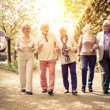 old people walking in the park sunny happy medical alert systems